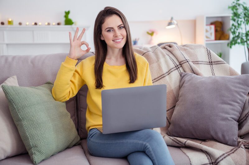 Woman placing mug bet on laptop